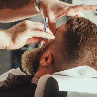A cut-throat razor shaping the line of a beard